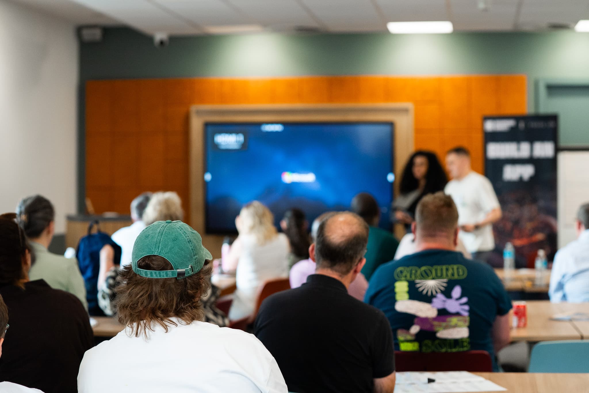 A full room of business owners watching a live demonstration on screen